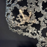 Détail Sculpture contemporaine Belisama Le Souffle de Philippe Buil, buste de femme à taille réelle en dentelle de métal acier et bronze avec étoiles fondues,  sur fond sombre.