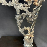 Détail Sculpture contemporaine Belisama Le Souffle de Philippe Buil, buste de femme à taille réelle en dentelle de métal acier et bronze avec étoiles fondues,  sur fond sombre.